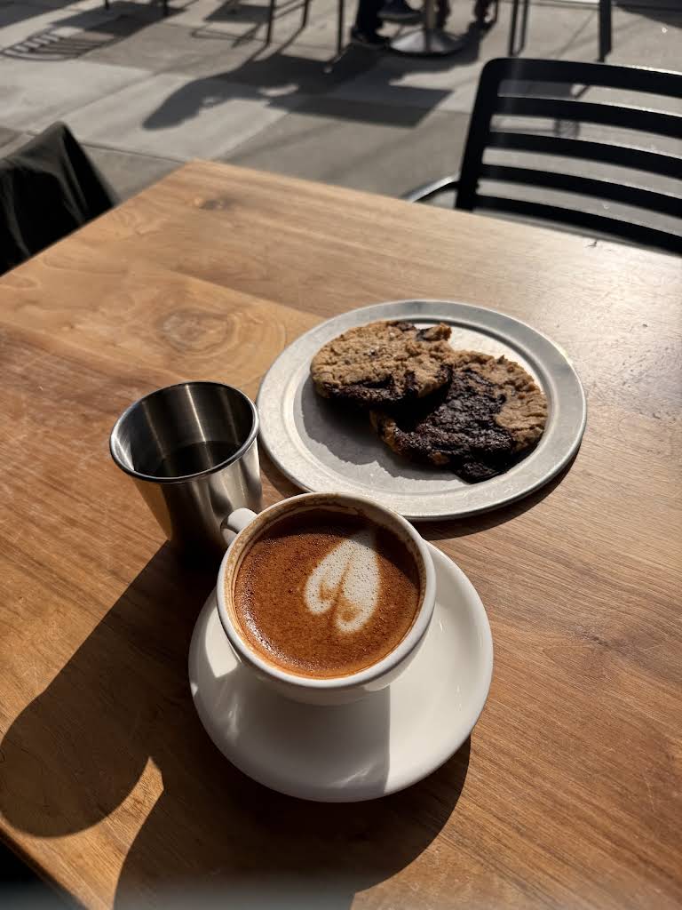 Latte and cookie on an outdoor table